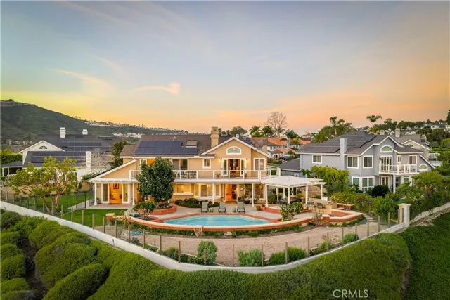 a view of a big house with a big yard and large trees