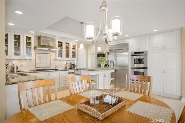 a large kitchen with kitchen island a large counter space dining table and stainless steel appliances