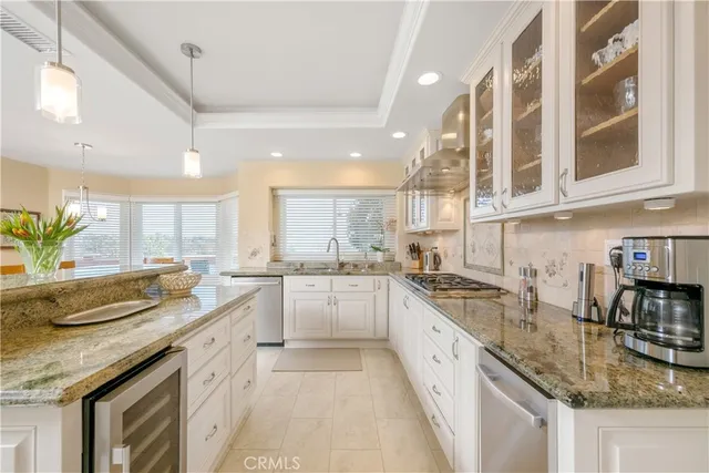 a large white kitchen with stainless steel appliances granite countertop a sink and dishwasher next to a large window