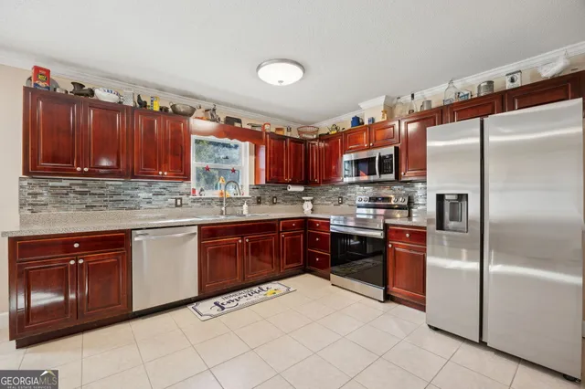 a kitchen with stainless steel appliances granite countertop a refrigerator and a sink
