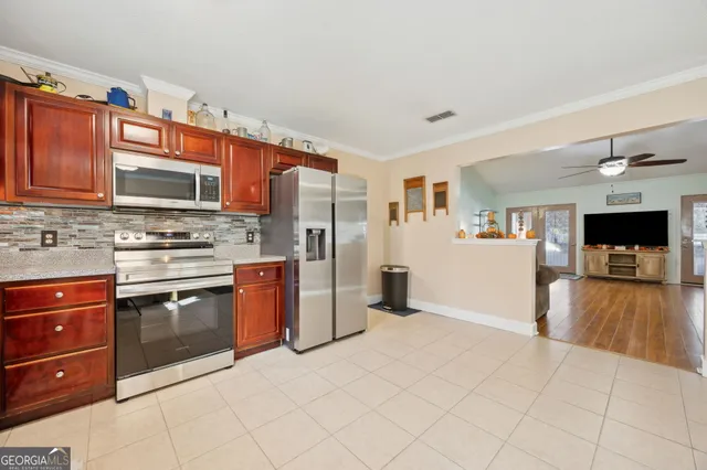 a kitchen with stainless steel appliances granite countertop a refrigerator and a stove top oven