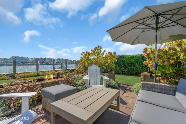 a view of a patio with furniture and a garden