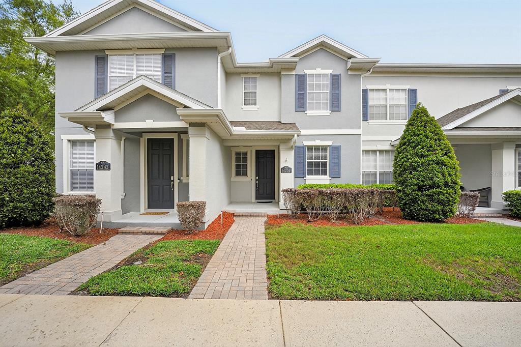 14239 Avenue Of The Groves Winter Garden, FL 34787 - Photo 1 of 54 a front view of a house with a yard and garage