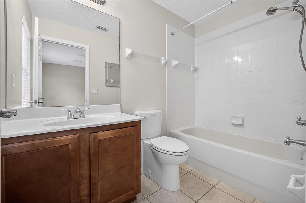 14239 Avenue Of The Groves Winter Garden, FL 34787 - Photo 18 of 54 a bathroom with a granite countertop sink a toilet and shower