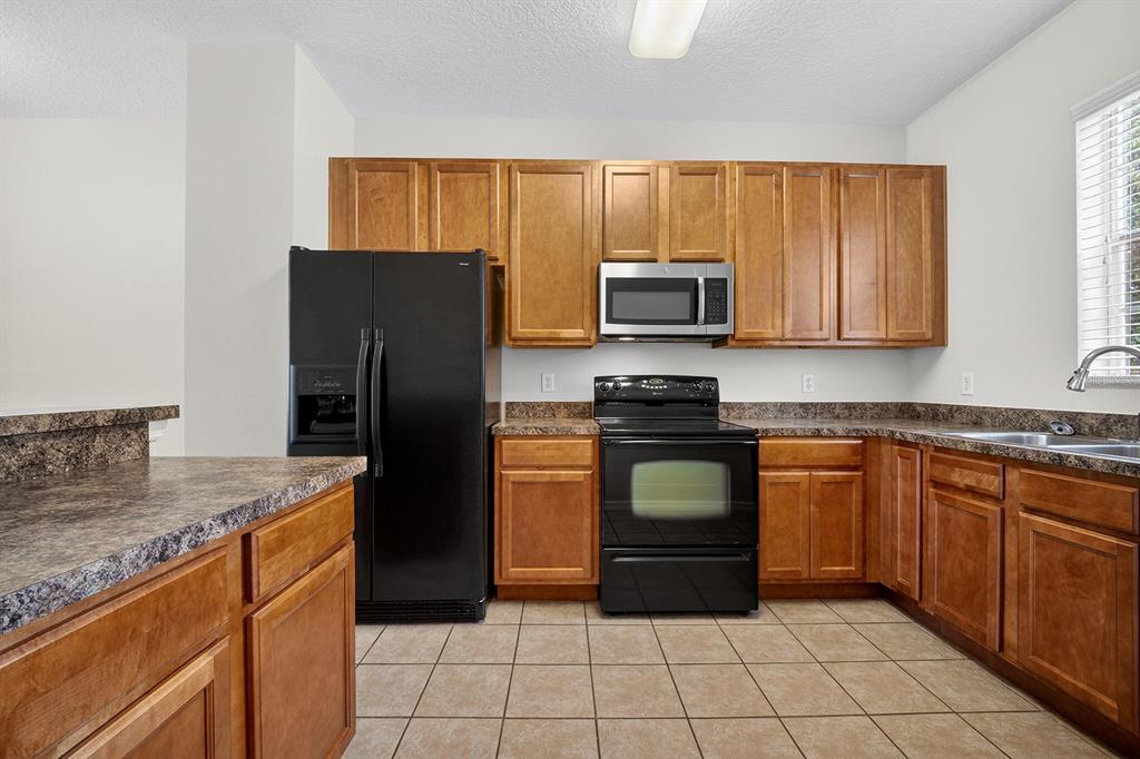 14239 Avenue Of The Groves Winter Garden, FL 34787 - Photo 8 of 54 a kitchen with stainless steel appliances granite countertop a refrigerator stove top oven and sink