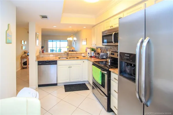 a kitchen with stainless steel appliances a sink a stove a refrigerator and cabinets