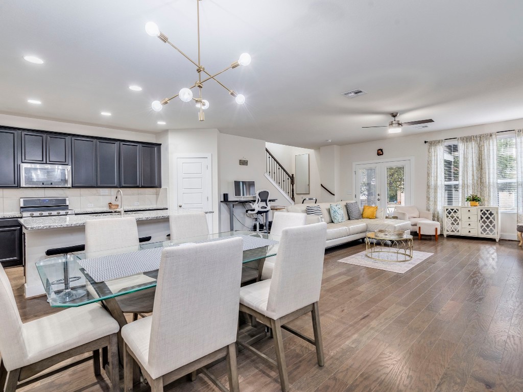 7408 Merrick Lane, Unit 42 Austin, TX 78745 - Photo 4 of 28 Dining space with stairway, a chic chandelier, dark wood-type flooring, recessed lighting, and ceiling fan