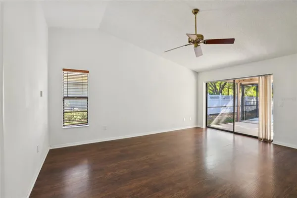 a view of empty room with wooden floor and ceiling fan