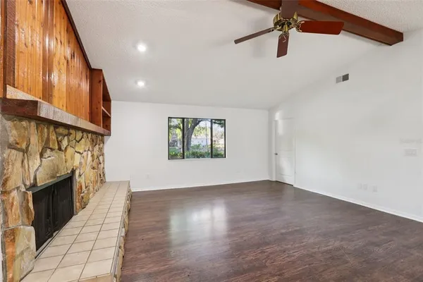 a view of a room with wooden floor and a ceiling fan