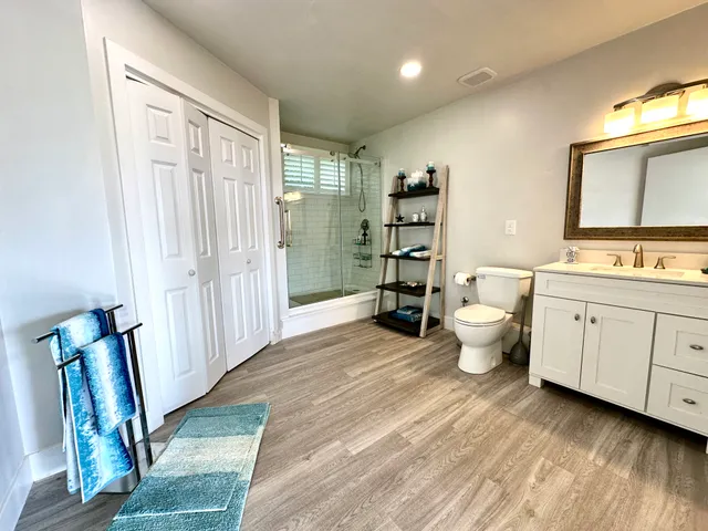 a bathroom with a toilet sink double vanity and mirror