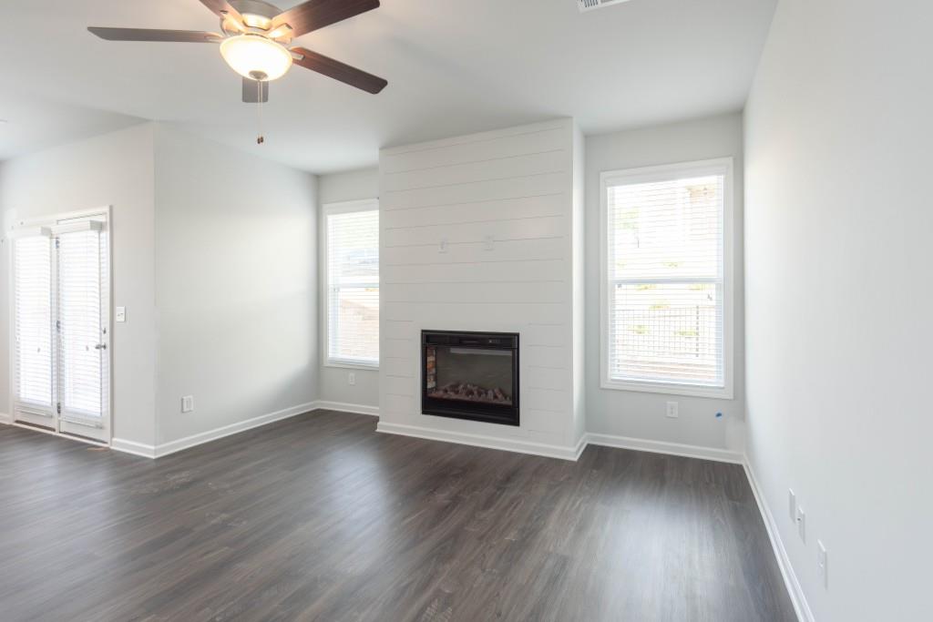 2773 Apperson Way Suwanee, GA 30024 - Photo 8 of 24 an empty room with wooden floor windows and fireplace
