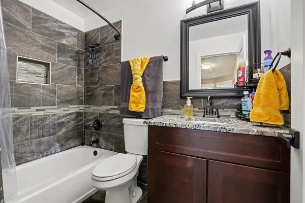 a bathroom with a granite countertop sink toilet and shower