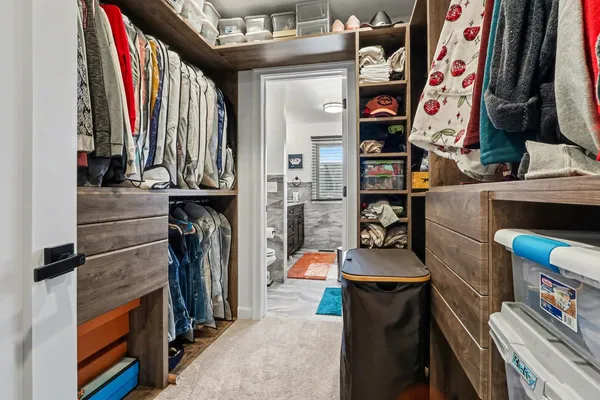 a view of walk in closet with clothes and shoes