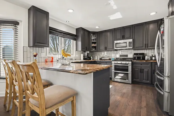 a kitchen with stainless steel appliances granite countertop a sink stove and refrigerator