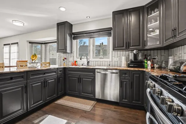 a kitchen with stainless steel appliances granite countertop a stove a sink and a microwave