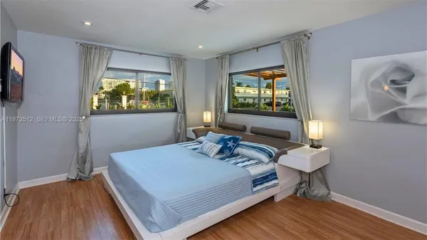 a bedroom with a bed and a flat screen tv