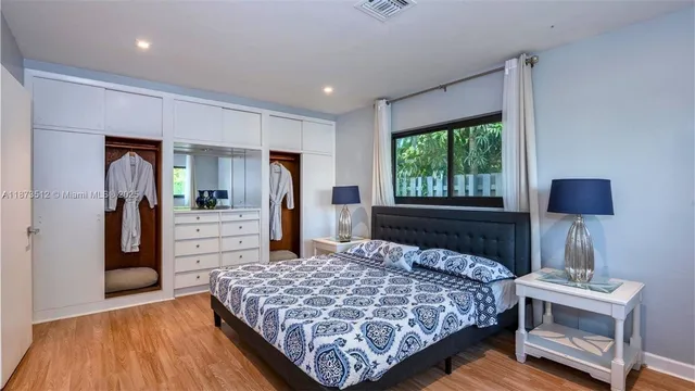 a bed sitting in a room next to a window and a television