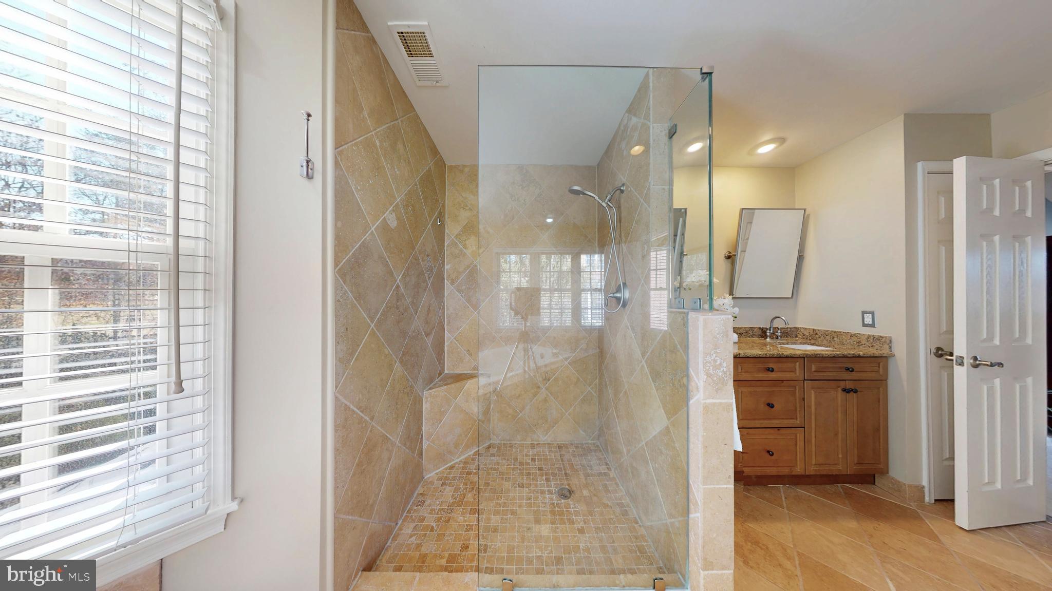 9728 Middleton Ridge Road Vienna, VA 22182 - Photo 42 of 81 a bathroom with a glass shower door and a sink