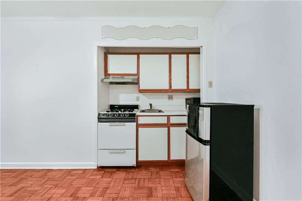 9430 Ridge Boulevard, Unit 1F Brooklyn, NY 11209 - Photo 2 of 6 a kitchen with stainless steel appliances granite countertop a stove a refrigerator and a microwave