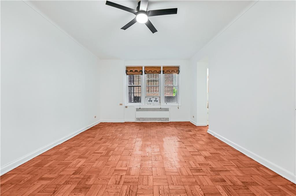 9430 Ridge Boulevard, Unit 1F Brooklyn, NY 11209 - Photo 3 of 6 an empty room with windows and fan