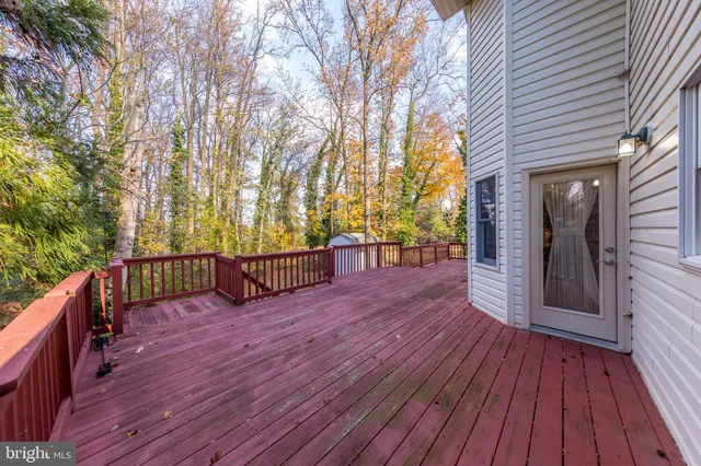 a view of a deck with wooden floor and fence next to a yard