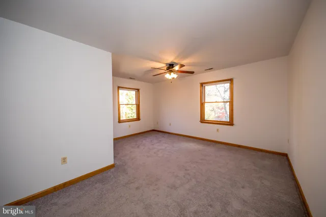an empty room with windows and closet
