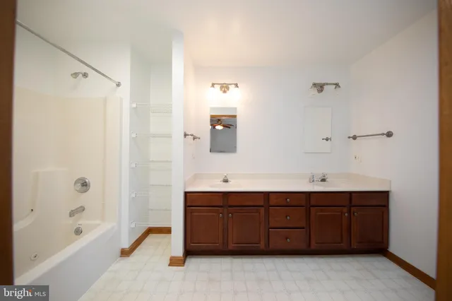 a bathroom with a double vanity sink mirror double and bathtub