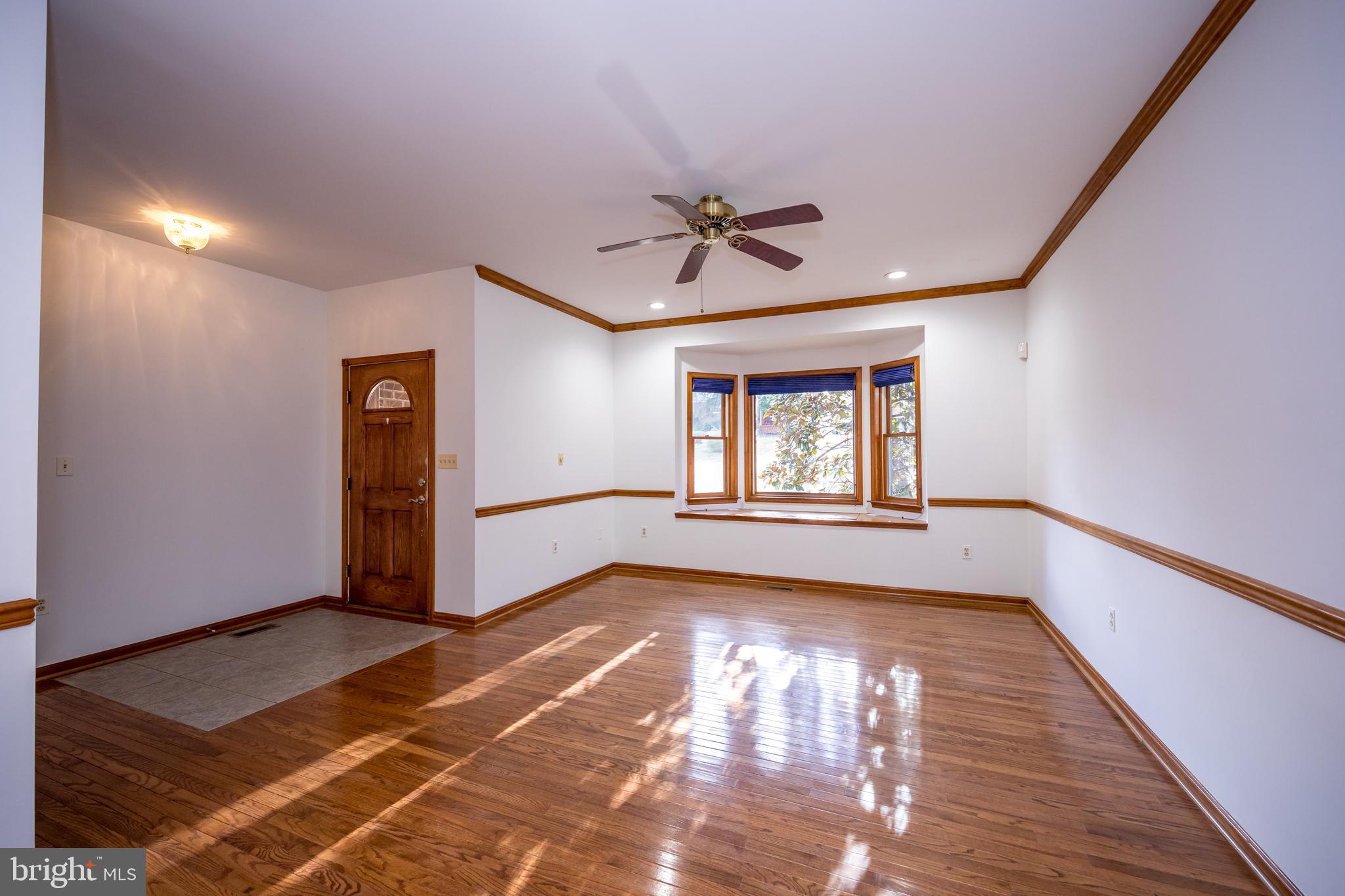 20 Glade Avenue Baltimore, MD 21236 - Photo 6 of 42 a view of an empty room with a window and wooden floor