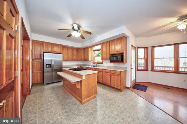 a large kitchen with stainless steel appliances granite countertop a stove refrigerator and microwave
