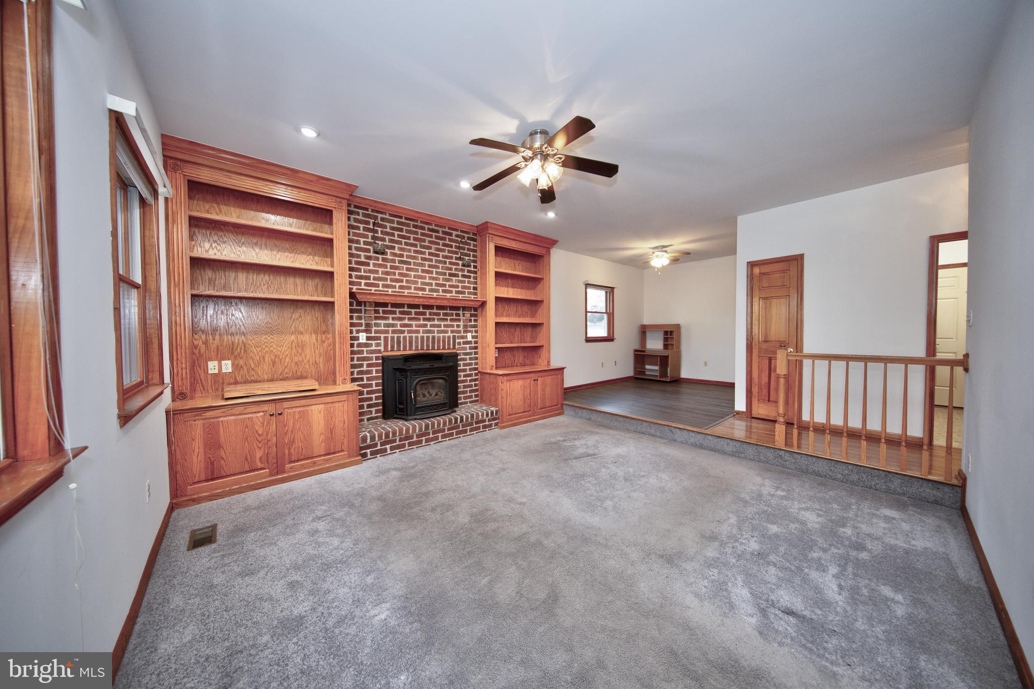 20 Glade Avenue Baltimore, MD 21236 - Photo 10 of 42 a view of a livingroom with a fireplace a ceiling fan and windows