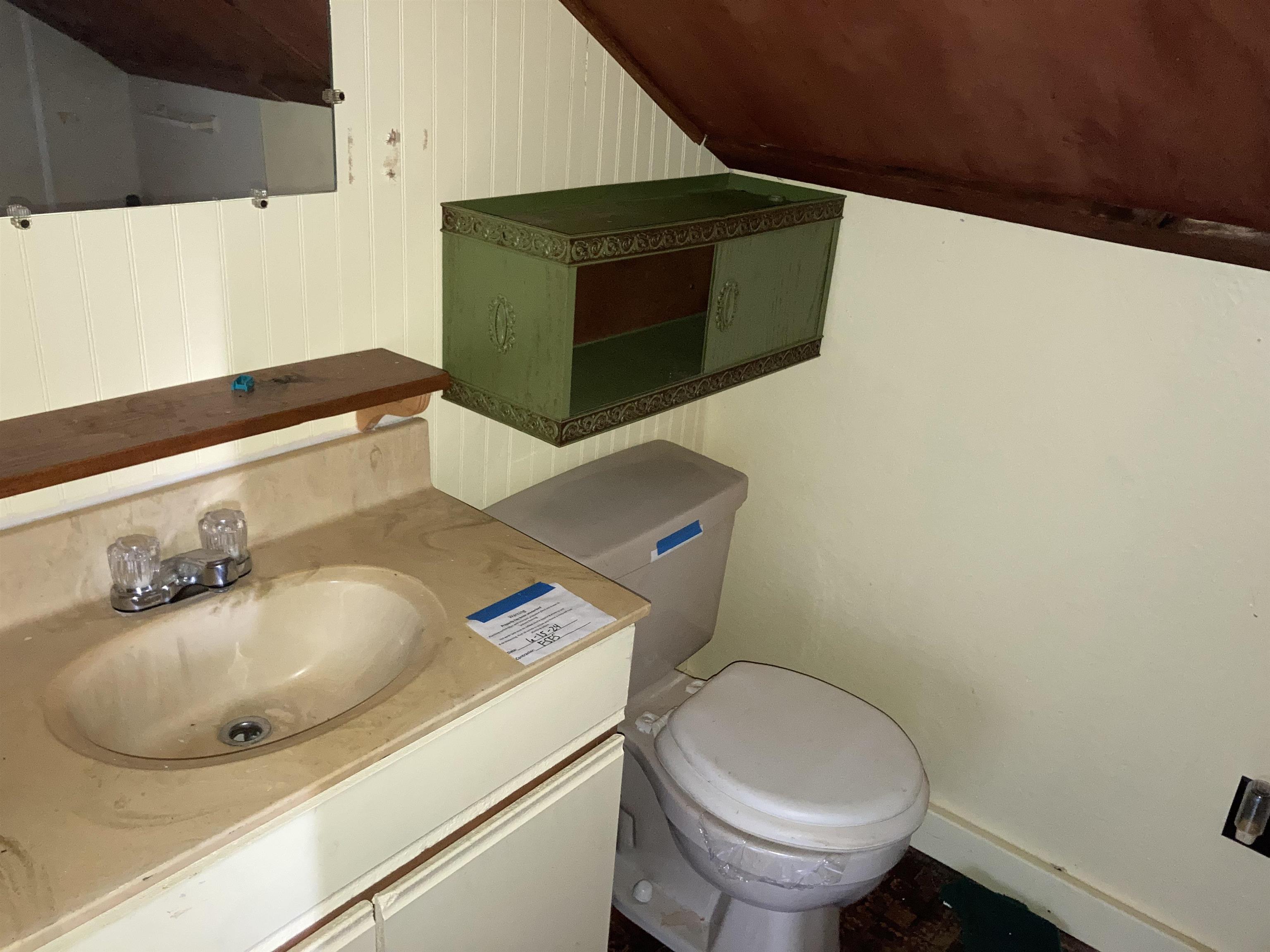 2460 Highway 79 Ridgely, TN 38080 - Photo 8 of 11 White beadboard paneling, built-in vanity with integrated sink, wall-mounted mirror, and decorative wall storage