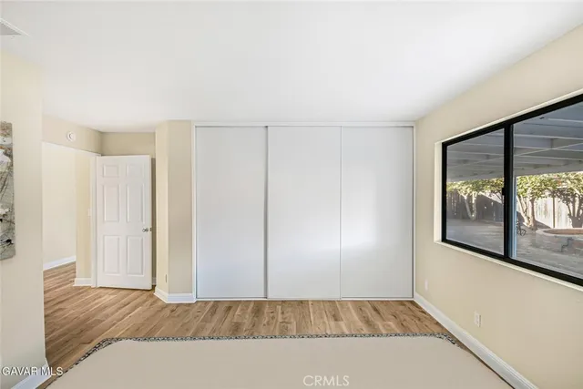 a view of a room with wooden floor and a window