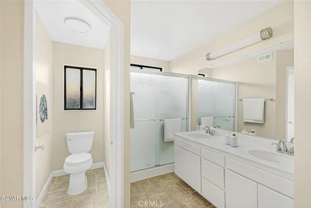 a bathroom with a double vanity sink mirror and toilet