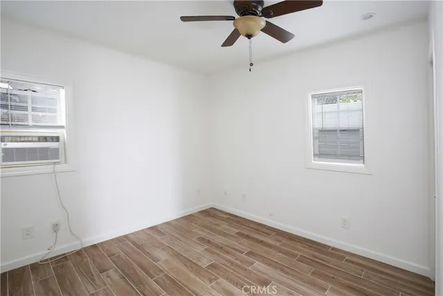 an empty room with a window and a ceiling fan