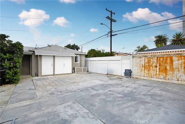 a view of a house with a backyard and potted plants