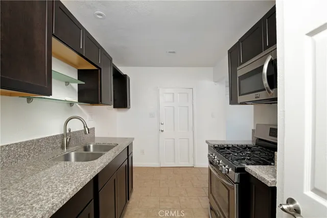 a kitchen with stainless steel appliances granite countertop a sink stove and microwave