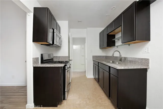 a kitchen with stainless steel appliances granite countertop a sink stove and microwave