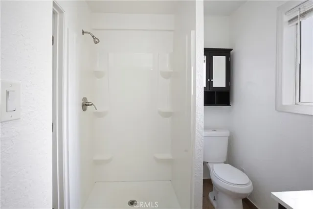 a white toilet sitting next to a bathroom sink and vanity