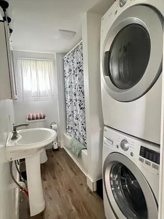 a bathroom with a sink mirror and a washer dryer