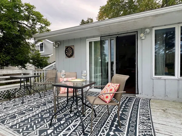 a backyard of a house with wooden floor outdoor seating and yard in the back