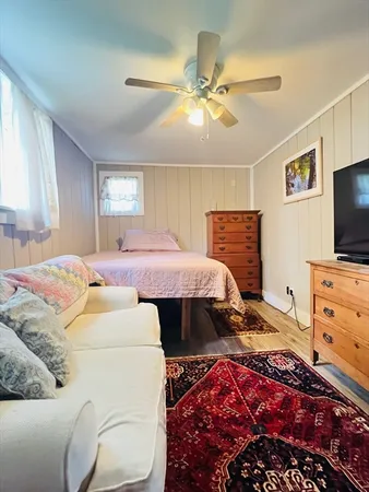 a bedroom with a bed and a flat tv screen on dresser