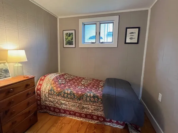 a bedroom with a bed and a lamp on dresser