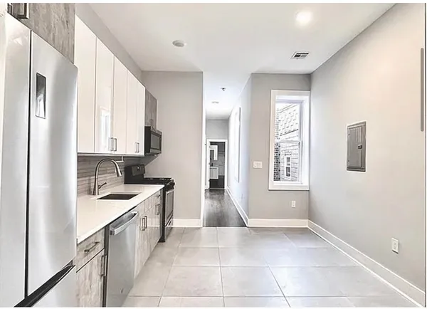 a kitchen with granite countertop a sink stove and cabinets