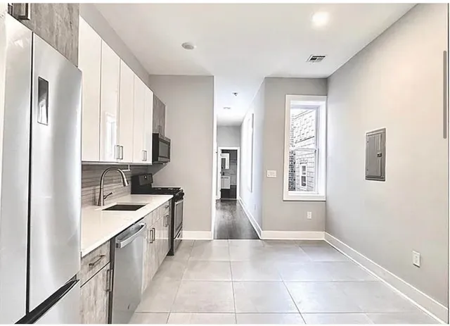 a kitchen with granite countertop a sink stove and cabinets