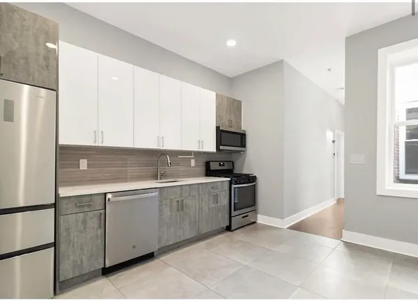 a kitchen with stainless steel appliances granite countertop a refrigerator and a sink