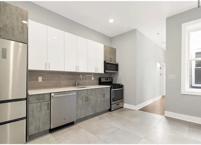 a kitchen with stainless steel appliances granite countertop a refrigerator and a sink