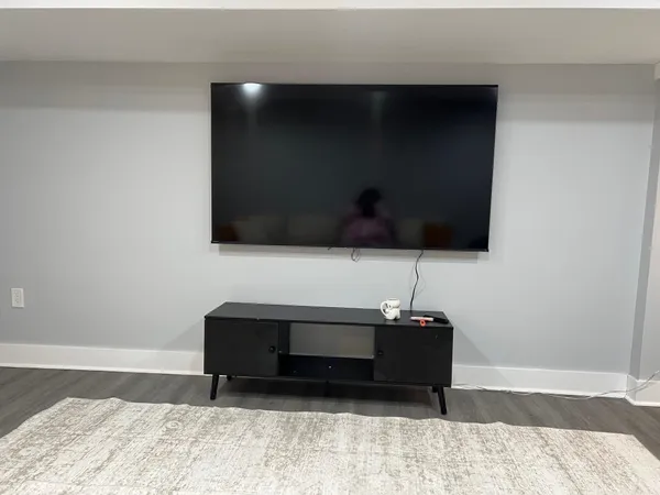 a living room with a flat screen tv and a lamp