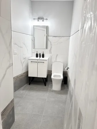 a bathroom with a toilet sink and mirror