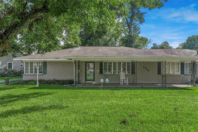 a view of a house with a yard and sitting area