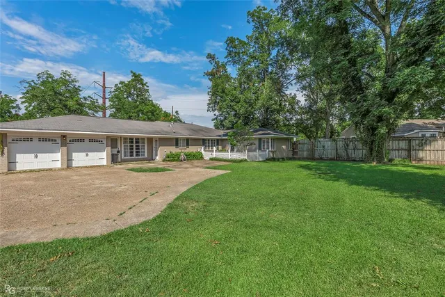 a front view of house with a garden